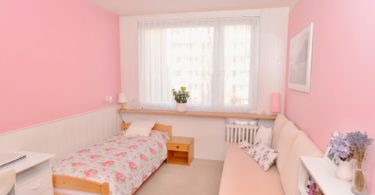 růžová ložnice s pohovkou a postelí