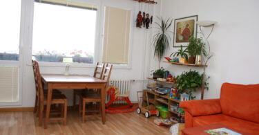 obývací pokoj s jídelním stolem a červená sedačka