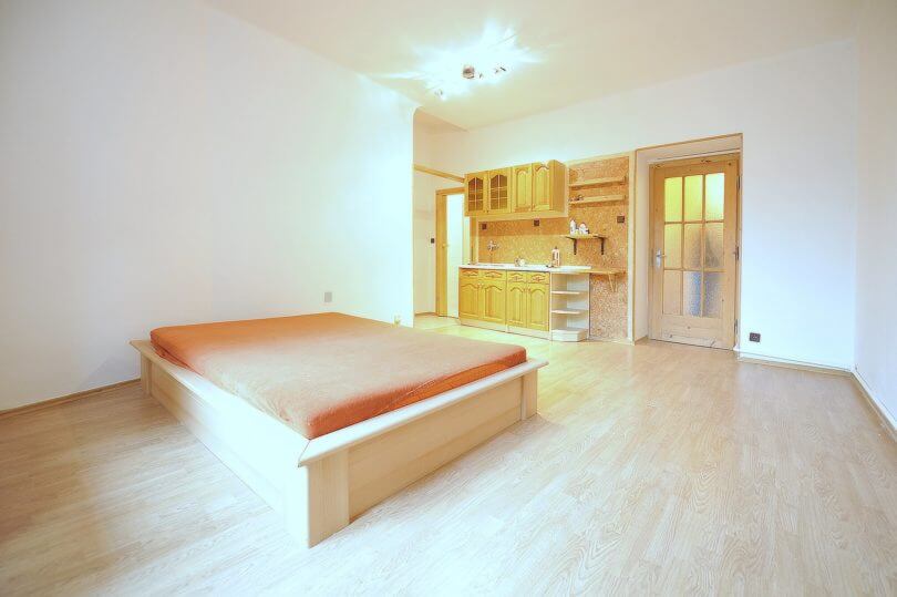 obývací pokoj s kuchyní, postelí a balkonem