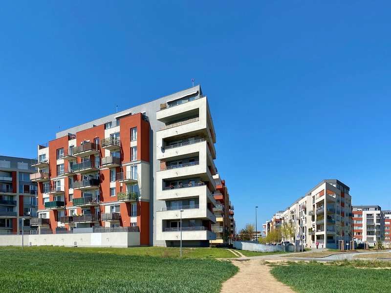 novostavby bytových domů, modrá obloha a zelený trávník