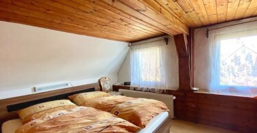 podkrovní místnost s manželskou postelí a dvěma okny