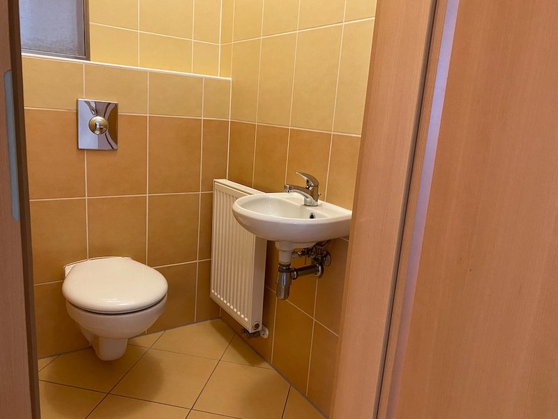 závěsná toaleta, WC, umyvadlo oranžové obklady