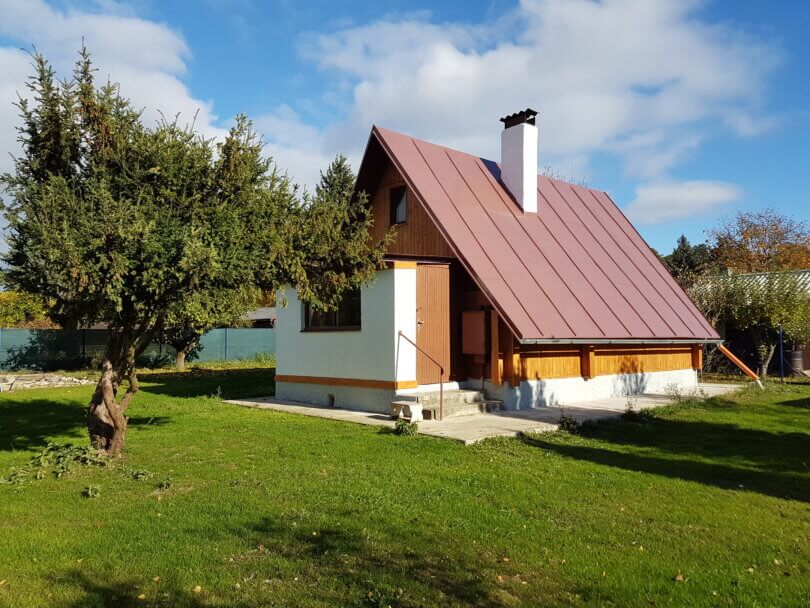 rekreační chata na rovném pozemku, před chatou strom